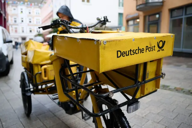 Eine Postbotin bei der Arbeit. | Foto: Philip Dulian/dpa
