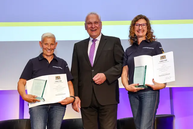 Für besondere Verdienste zeichnete Joachim Herrmann sechs Frauen und Männer der Bayerischen Sicherheitswacht aus, darunter Ingrid Steinegger (l.) und Sylvia Jähnig von der Sicherheitswacht München. Im Rahmen eines Streifengangs stellten beide eine junge Frau fest, die am Geländer einer Autobahnbrücke saß und sich augenscheinlich in den Tod stürzen wollte. Die Frau konnte dank des engagierten Einsatzes aller Beteiligten gerettet werden. | Foto: BayStMI / Daniel Löb