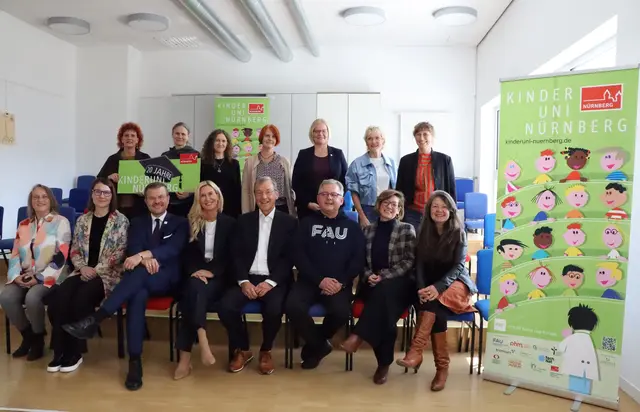 Die KinderUni feiert ihr 20-jähriges Bestehen, mit dabei sind neben Oberbürgermeister Marcus König (3.v.l., vordere Reihe) Initiatoren und langjährige Wegbegleiter.  | Foto: Janka Menzel / Stadt Nürnberg