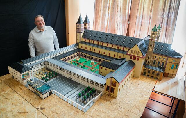 Kitzingen (dpa/lby) - Ein wahres Kunstwerk aus geschätzten 2,5 Millionen Lego-Steinen hat ein 72-Jähriger in Kitzingen geschaffen: Ein halbes Jahr und rund zehn Stunden am Tag hatte er am Nachbau des Würzburger St.-Kilians-Dom getüftelt - selbst sonntags, wie Reinhold Dukat erzählte. Überschlagen wären das rund 1800 Arbeitsstunden. Hinzu kommt die Planung, die schon ein Jahr zuvor begonnen hatte.
Dafür ist Dukat, der Kunstgeschichte im Master studiert, mehrfach vor Ort gefahren, inspizierte jede Ecke des Doms, prägte sich architektonische Merkmale ein, machte Fotos und baute das Kunstwerk zunächst «in der eigenen Fantasie» nach - bis der rund drei Meter lange und drei Meter breite Dom nach und nach entstand.
Der Miniatur-Dom ist mit kleinsten Details bestückt und gewährt sogar Einblicke in die Innenräume: Altar, Orgel mit Chor, eine Darstellung von Adam und Eva, Bäume auf dem Innenhof. «Den Chor kann man rausziehen, dann sieht man die Krypta», sagte der Wahl-Franke, der ursprünglich aus Westfalen kommt.
«Mein Ziel ist es, dass sich mehr Leute Gedanken über Architektur machen und nicht nur achtlos an Gebäuden vorbeigehen», sagte der gelernte Diplom-Betriebswirt. Seine Frau halte ihm für das Hobby den Rücken frei.
Schon im Jahr 2018 hatte Reinhold Dukat die Würzburger Residenz gebaut - aus geschätzten eineinhalb bis zwei Millionen Steinen und in rund 1000 Arbeitsstunden. Doch für den neuen Bau musste er die Mini-Residenz zerstören - schließlich habe er die Lego-Steine gebraucht. «Die Erinnerung ist ja da und die neue Herausforderung hat mich getröstet.» | Foto: Nicolas Armer/dpa/Archivbild
